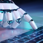 white robotic hand touches the spacebar of a computer keyboard with its pointer finger