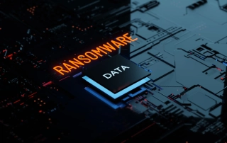 This image features a digitally rendered scene of a circuit board, focusing on themes of cybersecurity and digital threats. The word "RANSOMWARE" glows in a striking red hue across the center, indicating the theme of the image. Adjacent to it, "DATA" is illuminated in blue, emphasizing the target of such cyber threats. The background shows a high-tech circuit board design in blue and black tones, with intricate patterns and electronic components. The overall mood of the image is dark and foreboding, underlining the danger and seriousness of cyberattacks like ransomware.