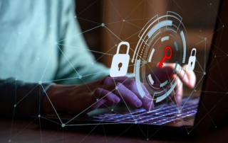 Cybersecurity training to prevent ransomware. The image shows a conceptual representation of cybersecurity, blending human interaction with digital elements. In the foreground, hands are typing on a laptop keyboard, indicating an active engagement with technology. Overlaid on the scene is a futuristic graphic interface featuring a circular target-like design, with a glowing red key symbol at its center. This symbolizes access, security, or unlocking sensitive information. Surrounding the circular graphic are padlock icons, emphasizing data protection and security measures. Additionally, thin white lines and dots form a network pattern across the image, representing interconnected systems or a web of digital connections. The background is softly blurred, focusing attention on the hands and the digital interface, creating a blend of human and technological elements. The image conveys themes of cybersecurity, digital access, and the importance of safeguarding data.