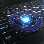 Active Directory ransomware hardening. A close-up of a keyboard shows a glowing blue circular digital padlock hovering over it, like a hologram. The lock is surrounded by a futuristic interface with lines and symbols, giving the impression that the keyboard is secured by advanced cyber defenses.