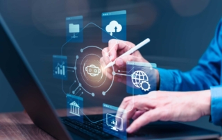 Ransomware risk management framework. A professional wearing a blue shirt is interacting with a virtual, transparent interface emerging from their laptop. They use a stylus pen, suggesting precise control. Floating around their hands are various icons symbolizing technology, including cloud services, data analytics, global connectivity, finance or banking, and artificial intelligence. The image conveys the themes of digital transformation, data analysis, and secure management through technology.