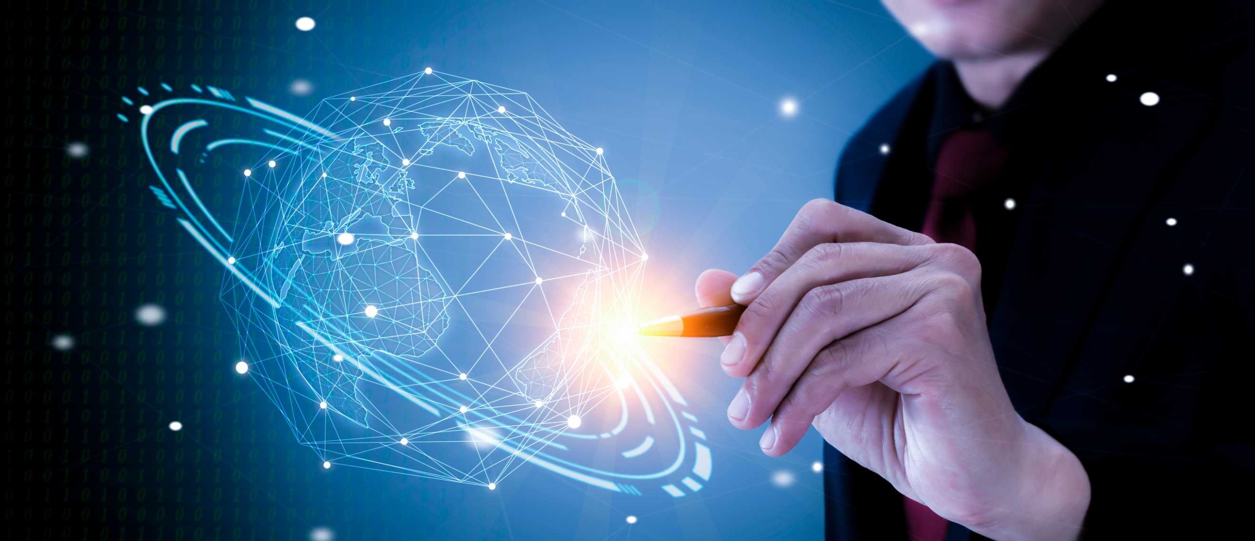 Infrastructure Security Monitoring. A hand holds a stylus and appears to draw or interact with a 3D holographic globe composed of geometric patterns and data points, symbolizing innovation, global networks, or cybersecurity visualization.