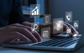 Phishing Simulation Training for Teams. Hands typing on a laptop keyboard. Floating icons above the laptop represent email, file search, AI processing, cloud storage, and phone support. It symbolizes multitasking in a digital workspace and interaction with advanced software systems.