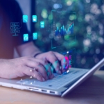 Ransomware tabletop exercise planning. This image shows a close-up of a person typing on a white laptop outdoors. The scene is visually enhanced with digital overlays — glowing, transparent icons and data charts that appear to float above the laptop. These graphics include bar charts, pie charts, folder structures, and magnifying glasses, suggesting data analysis, cybersecurity, or tech operations. The person’s hands are the main focus, and the background is softly blurred greenery, giving a natural, calm setting that contrasts with the high-tech visual effects layered on top. The image conveys a theme of working on advanced technology or cybersecurity in a remote or casual environment.