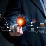 Cloud-Native App Security. A person dressed in a dark suit is pointing with their index finger toward a glowing digital interface. Icons extend outward in a network-like pattern and include symbols for email, e-commerce, analytics, and advertising. A glowing globe beneath the finger symbolizes global connectivity and interactive digital marketing.