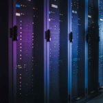 Cybersecurity Mesh Solutions. A person stands in a server room lined with glowing, tall server racks, holding a laptop and checking the equipment.