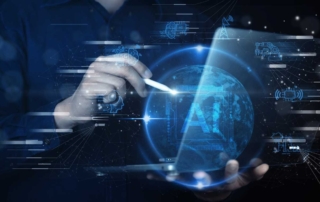 MFA Deployment Strategies. A person is using a stylus to interact with a glowing 3D digital globe. The background is a futuristic, dark interface filled with motion graphics and holographic projections, including tiny vehicles and industrial equipment. The visual suggests global digital infrastructure, smart technology, or connected industries.