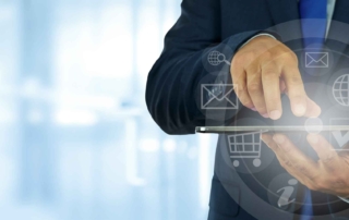 Zero Trust Network Implementation. A business professional in a suit uses a tablet device. Overlay icons are arranged in a circular interface around the device, featuring symbols for email, shopping cart, user profiles, globe, and documents. The person is tapping the screen, emphasizing business operations, mobile productivity, or cloud computing.