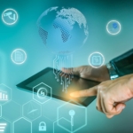 OT Security Best Practices. A businessperson’s hand touches a tablet emitting glowing icons like a globe, document, padlock, and various analytics symbols. The background is a gradient blue-green, evoking an advanced technology or cyber defense theme.