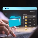 dlp-policy-implementation DLP Policy Implementation. Hands typing on a laptop, with a translucent blue window projected above it displaying digital folders and file names. The image symbolizes file management, cloud storage, or secure document access.